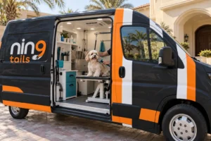 Dog being brushed inside a mobile pet grooming van outside a UAE villa.